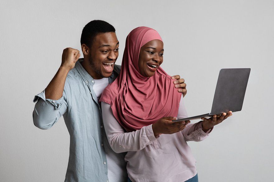 Happy couple using Dan Ata App on laptop
